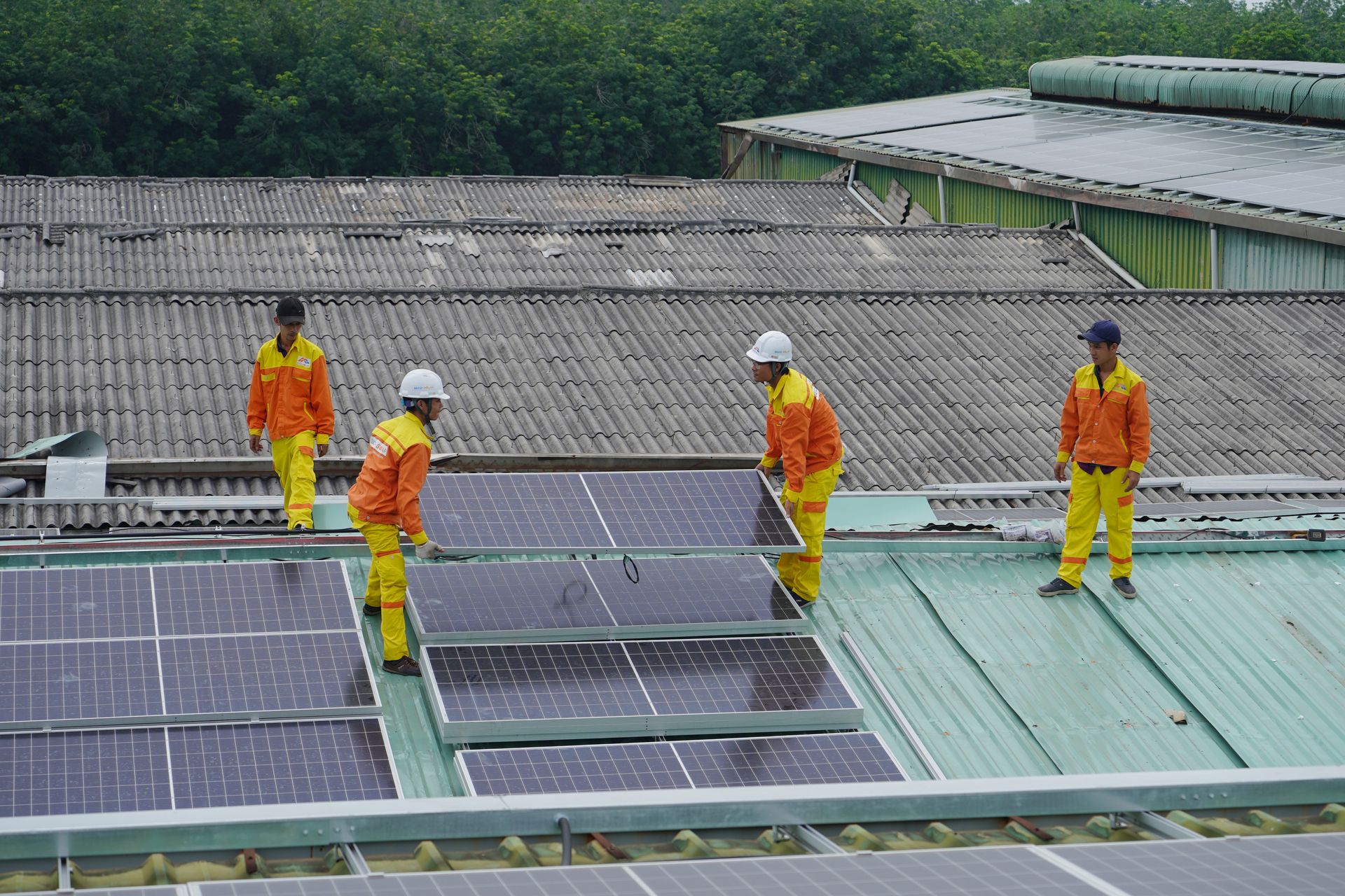 Installers fitting solar panels on a house roof