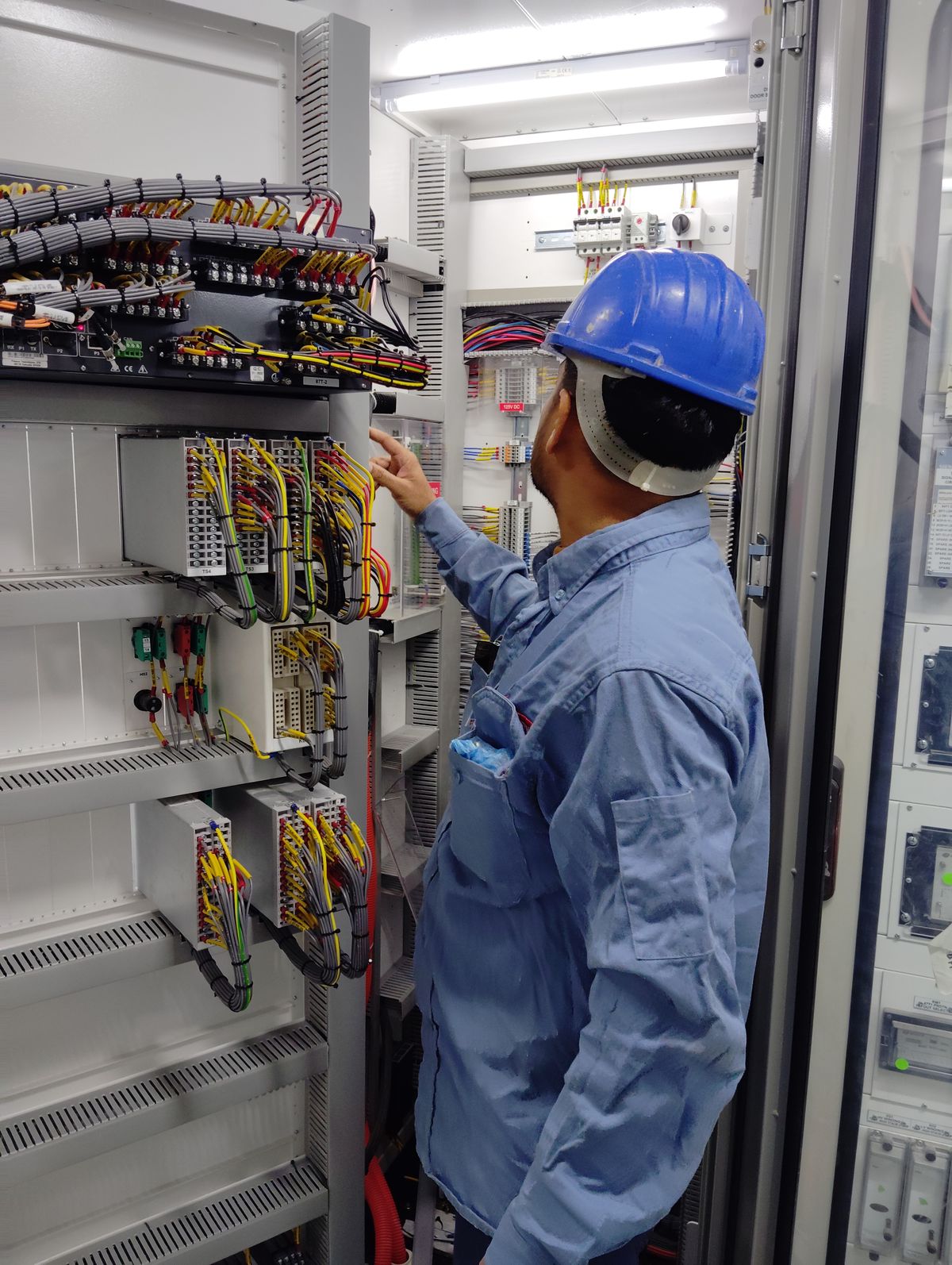 An electrician inspecting a control panel on site