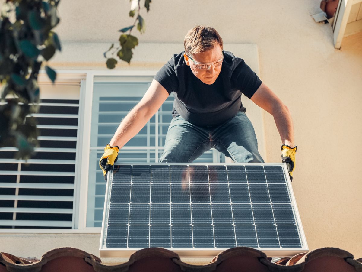 Solar panel being fitted on a pitched house roof