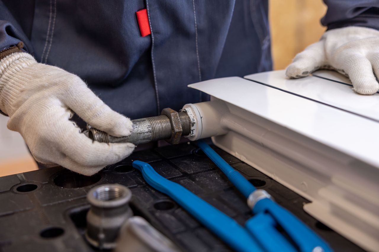 Plumber repairing a burst pipe connection